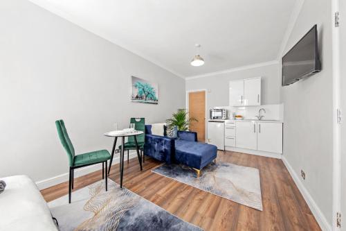 un soggiorno con divano e tavolo di Stunning studio flat with free on-street parking! a Plumstead