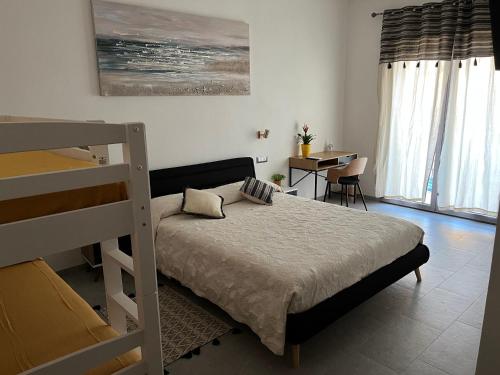 - une chambre avec des lits superposés et un bureau dans l'établissement Baboe Affittacamere IUN F1037, à Torre Grande