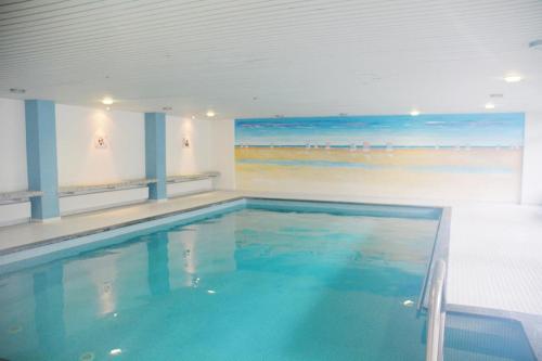 a swimming pool with blue water in a building at Iderhoff Iderhoff 19 in Norderney