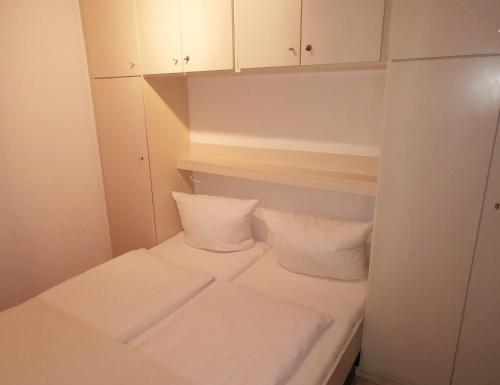 a small room with a bed with two pillows at Europäischer Hof Eurohof 22 in Norderney