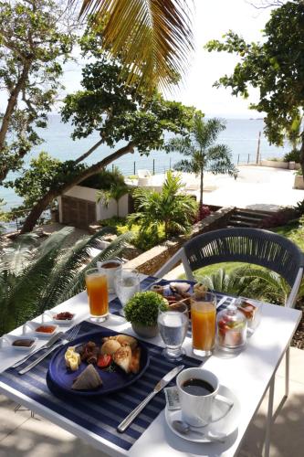a table with a plate of food on it at Aria By LD Hotel Boutique in Pampatar