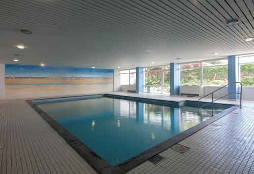 a large swimming pool in a building with a beach at Iderhoff Iderhoff 18 in Norderney