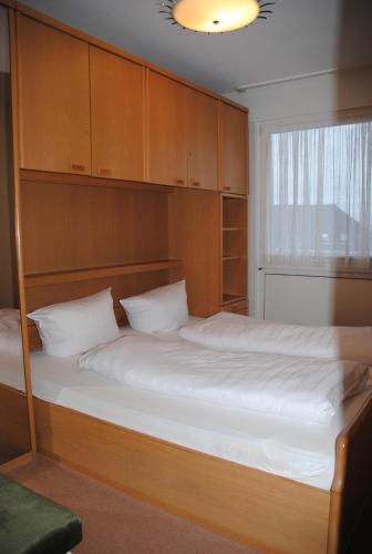 ein Schlafzimmer mit einem großen Bett und Holzschränken in der Unterkunft Iderhoff Iderhoff 03 in Norderney