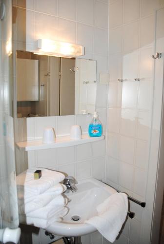 ein Badezimmer mit Waschbecken, Spiegel und Handtüchern in der Unterkunft Iderhoff Iderhoff 03 in Norderney