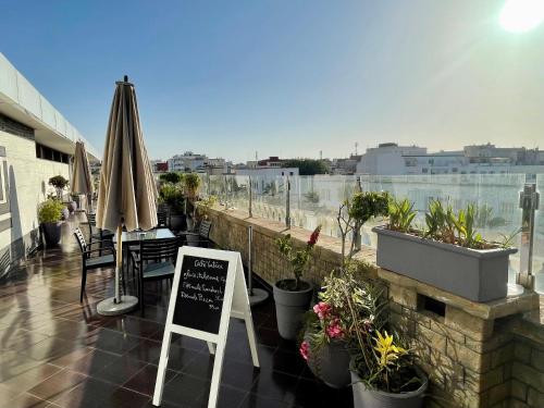 a restaurant with a sign on a balcony with plants at Hotel Lutece in Rabat