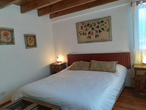 a bedroom with a white bed with two night stands at La Roca de la Patagonia in Villa La Angostura