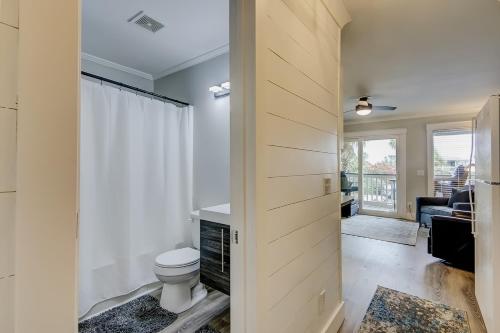 a bathroom with a toilet and a door to a living room at Sea Cabin 121-B in Isle of Palms