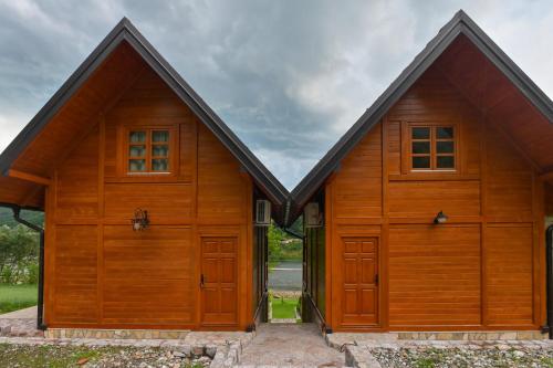 a large wooden building with two doors at Vikendica pored Drine in Bajina Bašta