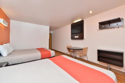 a hotel room with two beds and a flat screen tv at Motel 6-Meridian, ID - Boise W in Meridian