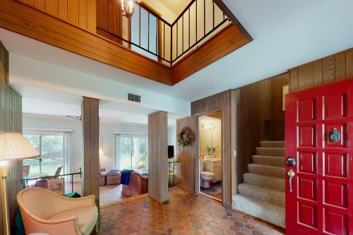 a living room with a red door and a staircase at The Getaway 205 in Glynn Haven