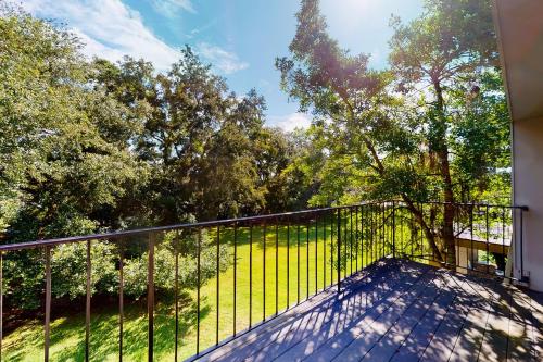 a balcony with a fence with trees in the background at The Getaway 205 in Glynn Haven