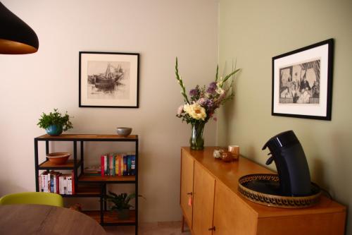 una stanza con una scrivania con un vaso di fiori sopra di Holiday Apartment Al 't Sanna a Geraardsbergen