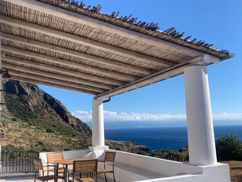 a patio with a wooden pergola overlooking the ocean at La casa blu superior in Lipari