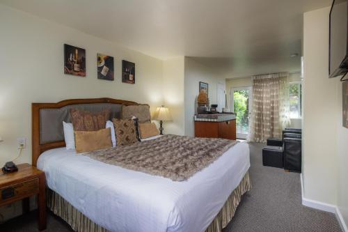 a bedroom with a large bed and a window at The Vendange Carmel Inn & Suites in Carmel