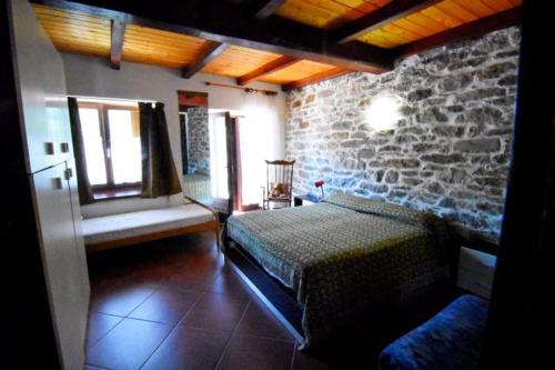 a bedroom with a bed and a stone wall at Peter Ranch 3 in Vico Canavese