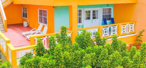 an orange house with chairs on a balcony at Belle View Apartment Villas in Laborie
