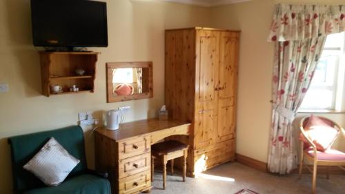 een kamer met een houten bureau en een spiegel bij Ballyraine Guesthouse in Letterkenny