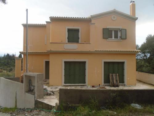 una casa en construcción con puertas verdes de garaje en Ligeris house 1 in Agioi Deka en Áyioi Dhéka