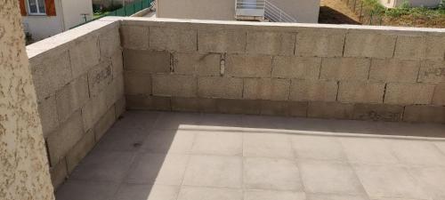 a concrete retaining wall next to a wall at Maison avec petite terrasse in Vescovato