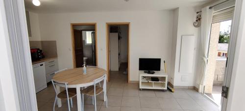 a kitchen with a table and a television in it at Maison avec petite terrasse in Vescovato