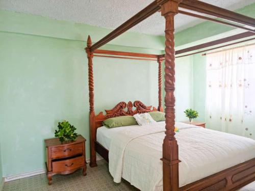 a bedroom with a canopy bed and a night stand at Belle View Apartment Villas in Laborie