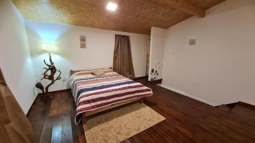 ein Schlafzimmer mit einem Bett mit einer gestreiften Decke in der Unterkunft UshuaiaHost in Ushuaia