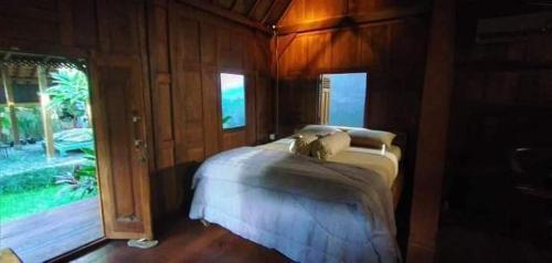 a bedroom with a bed in a room with a window at Klotok Surf Shack in Klungkung