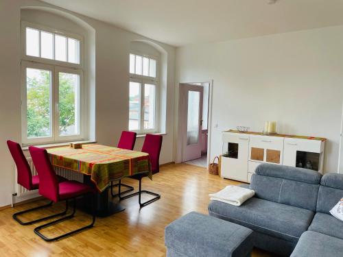 ein Wohnzimmer mit einem Tisch, Stühlen und einem Sofa in der Unterkunft "Glück auf" Lichtdurchflutete schicke Ferienwohnung in Zwickau in Zwickau
