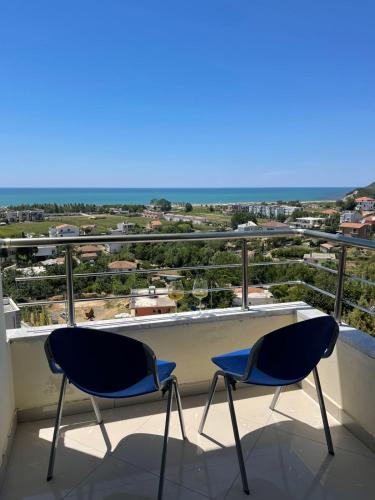 two chairs on a balcony with a view of the ocean at MEGA Apartments in Fushë-Draç