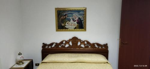 Villa Bonaffini في Mazzarino: سرير في غرفة نوم مع صورة على الحائط