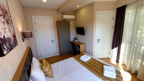 a bedroom with a bed in a room with two doors at Falcon Boutique Hotel in Tbilisi City