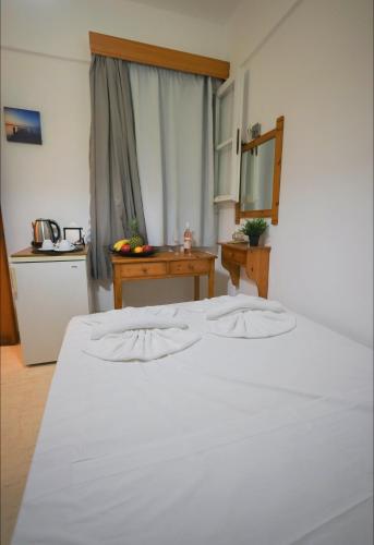 a large white bed in a room with a kitchen at Malia Boutique Studios in Malia