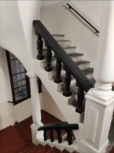 un escalier avec des balustrades noires dans une maison dans l'établissement Appartement 2 minutes de la mer Nice vieille ville, à Nice