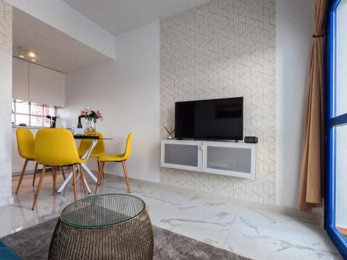 ein Wohnzimmer mit einem Fernseher an der Wand in der Unterkunft Arilvia good vibes only in Costa Calma