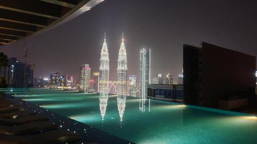 a swimming pool with a view of a city at night at Eaton Residence KLCC in Kuala Lumpur