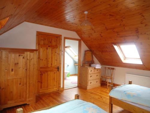 1 dormitorio con cama y techo de madera en Portmagee Seaside Cottages en Portmagee