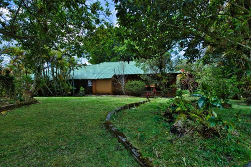 a house with a green roof and a yard at Hotel Villa Zurqui in San José