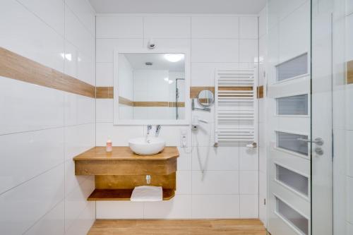 a white bathroom with a sink and a shower at Płaczewo in Starogard Gdański