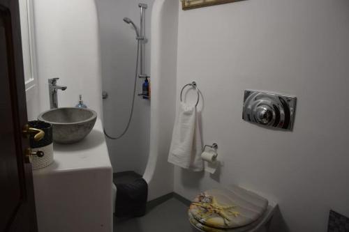 a white bathroom with a sink and a toilet at Το Πέτρινο in Kithnos