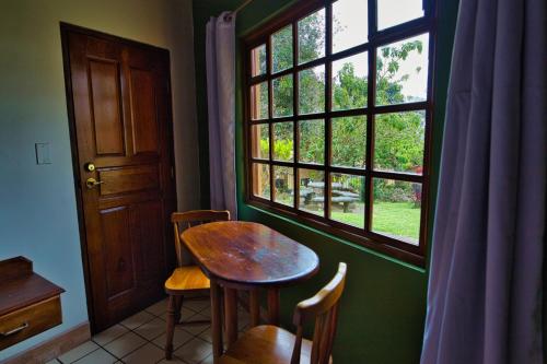 a table and chairs in a room with a window at Hotel Villa Zurqui in San José
