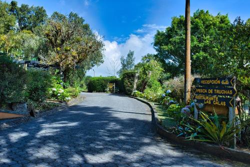a winding road with a sign in a garden at Hotel Villa Zurqui in San José