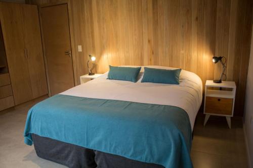 1 dormitorio con 1 cama grande con almohadas azules en BOG Norway, en Villa La Angostura