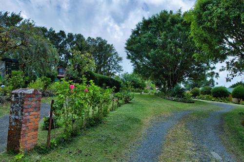 a garden with flowers and a brick fence at Hotel Villa Zurqui in San José