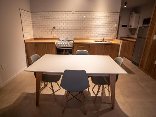 a kitchen with a table and chairs in it at BOG Norway - Departamentos Céntricos in Villa La Angostura