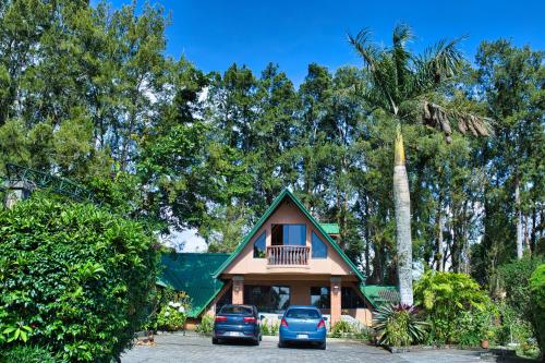 a house with two cars parked in front of it at Hotel Villa Zurqui in San José