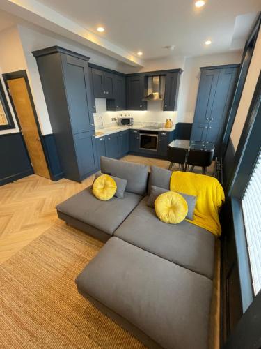 a living room with a gray couch with yellow pillows at Roe Valley Apartments in Limavady