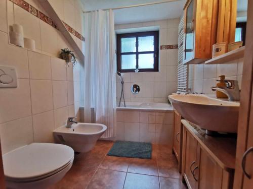 bagno con 2 lavandini, servizi igienici e vasca di Appartement Sisipark a Bad Ischl