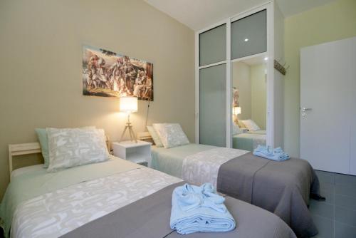 a bedroom with two beds and a painting on the wall at Seaside, relaxing family house with playground! Villa Lavrys 4 in Marathi