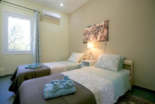 a bedroom with two beds and a window at Seaside, relaxing family house with playground! Villa Lavrys 4 in Marathi