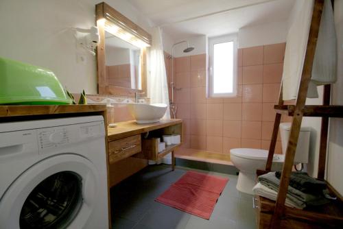 a bathroom with a washing machine and a sink at Seaside, relaxing family house with playground! Villa Lavrys 4 in Marathi